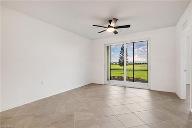 Spare room with ceiling fan and light tile floorin