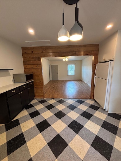 Kitchen featuring refrigerator, dark cabinets, re