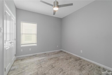 Tiled spare room featuring ceiling fan