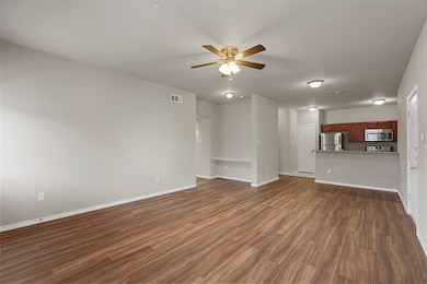Unfurnished living room with dark wood finished floors and ceiling fan