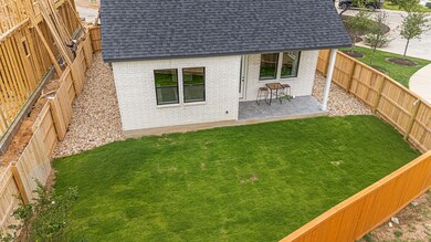 Back of property featuring brick siding, roof wit