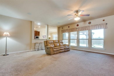 Living room featuring light carpet and a ceiling fan