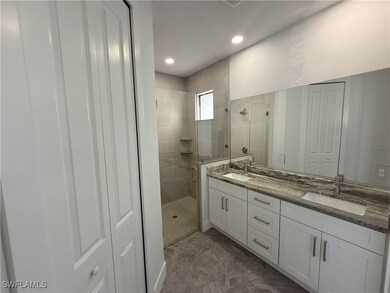 Full bathroom featuring a shower stall, double van