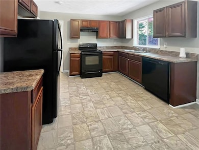 Kitchen with black appliances, a sink, and under c
