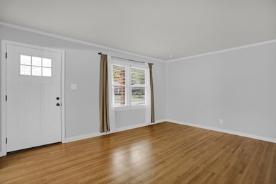 Entryway featuring ornamental molding and wood finished floors