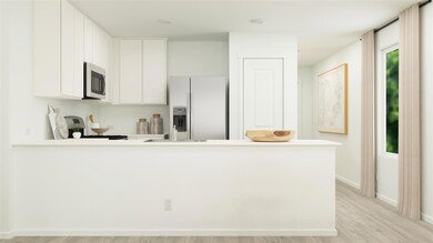 Kitchen with stainless steel appliances, white cabinetry, kitchen peninsula, and light hardwood / wood-style flooring