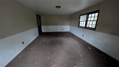 Empty room featuring a wainscoted wall and a textu