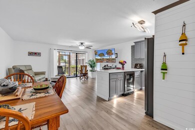 Kitchen with beverage cooler, gray cabinets, light countertops, a ceiling fan, and light wood-style floors