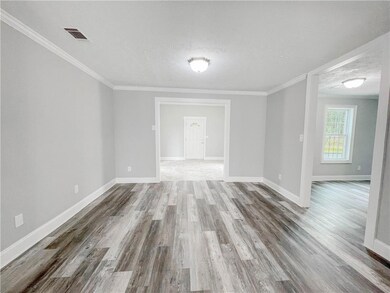 Unfurnished room featuring wood finished floors, crown molding, and a textured ceiling