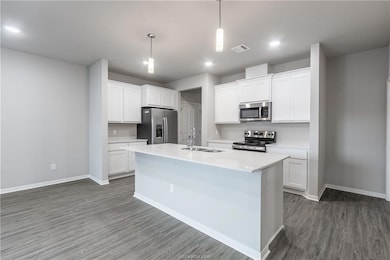 Kitchen featuring sink, white cabinetry, hanging l