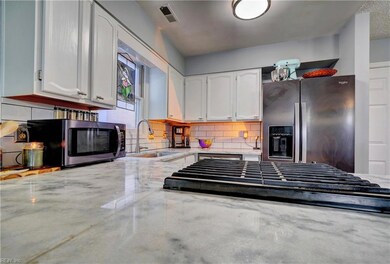 Kitchen Features Marble Countertops, Gas Cooktop, and Stainless Side-by-Side Refrigerator