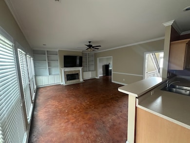 Unfurnished living room with a sink, a ceiling fan