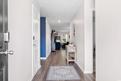 Hall with dark wood-style flooring and recessed lighting
