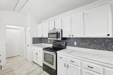 Kitchen with range with electric cooktop, white ca