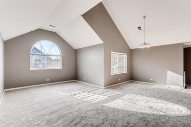 The living room is has a vaulted ceiling and lots 