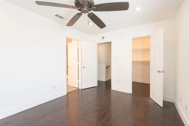 Unfurnished bedroom featuring dark wood-style flooring, recessed lighting, a spacious closet, and ceiling fan