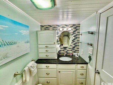 Bathroom with vanity, ornamental molding, and backsplash