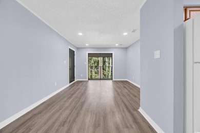 Empty room featuring a textured ceiling, wood finished floors, and recessed lighting
