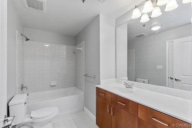 Full bathroom with tiled shower / bath combo, toil