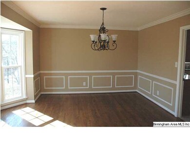 Dining room features hardwoods and a bay window wi