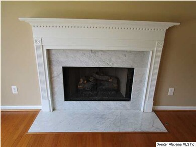 GAS LOG FIREPLACE IN FAMILY ROOM HAS MARBLE SURROU