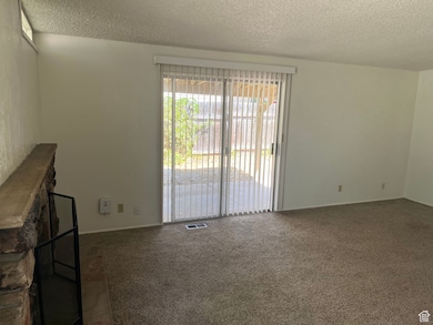 Carpeted spare room featuring a textured ceiling