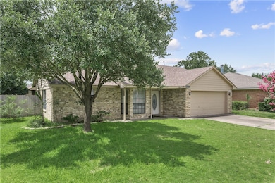 Ranch-style house with brick siding, a garage, a s