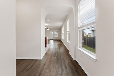 Hallway with dark wood-style flooring and arched 