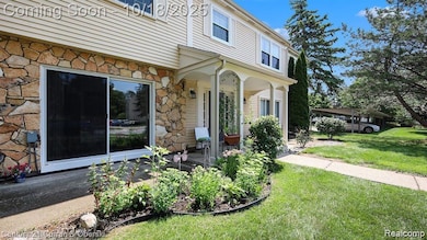 Doorway to property with stone siding, a lawn, and a porch
