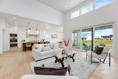 Living room with plenty of natural light, light wood-type flooring, recessed lighting, and a towering ceiling