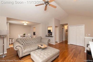 Living area featuring wood finished floors, ceiling fan, and high vaulted ceiling