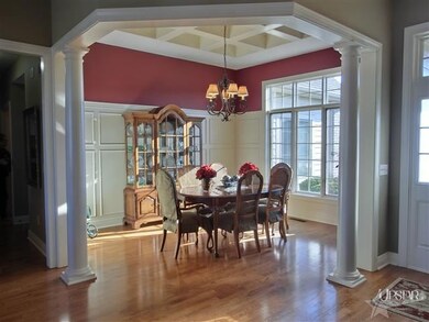 A formal dining room with pillars & a coffered cei
