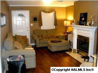 LIVING ROOM WITH GAS LOG FIREPLACE ACCENTED WITH RECESSED LIGHTING FROM CEILING.