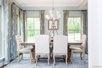 Dining room features hardwood floors, crown mouldi
