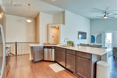 Kitchen with sink, hanging light fixtures, light wood-type flooring, and appliances with stainless steel finishes