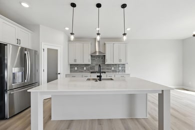 Loaded with upgrades, this lifestyle kitchen features decorative metal hood, horizonal tile backsplash, GE Appliances include upgraded fridge, double micro/oven combo, and dishwasher. Picture of actual home.