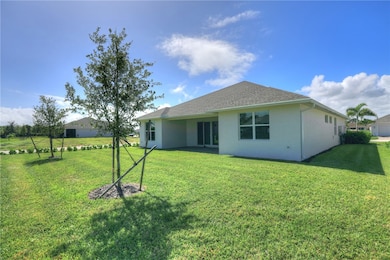 Back of house featuring a patio area, stucco siding, and a lawn