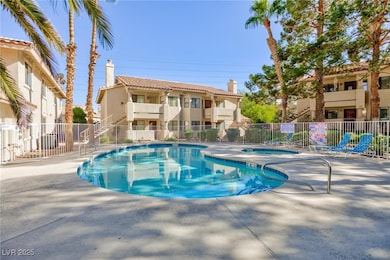 Community pool with a patio, fence, a community hot tub, and stairs