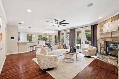 Living room with ceiling fan, french doors, a ston