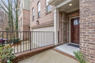 Property entrance featuring a garage and brick sid