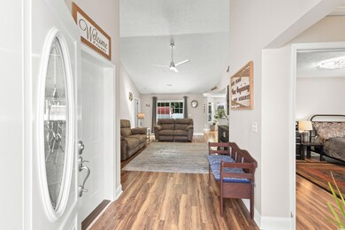 Living room with vaulted ceiling, ceiling fan, and