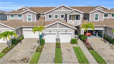 View of front of house with driveway, an attached garage, a tile roof, and stone siding