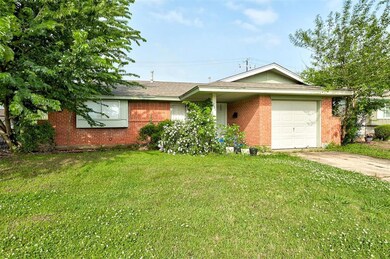 Single story home featuring a front yard and a gar