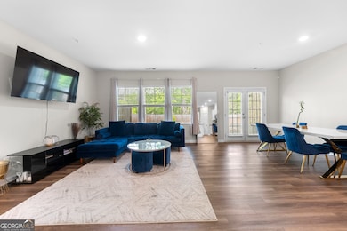 Main floor has a bright, open floorplan with a spacious living room, dining area and French doors to the outdoor garden and patio, overlooking a wooded area.