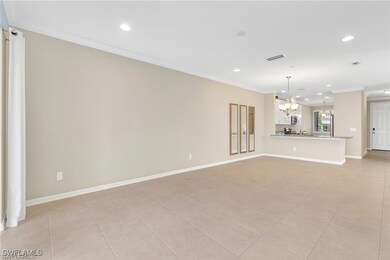 Unfurnished living room with crown molding, light tile patterned floors, recessed lighting, and a chandelier