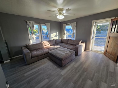 Living room with wood finished floors, ceiling fan, and a textured ceiling