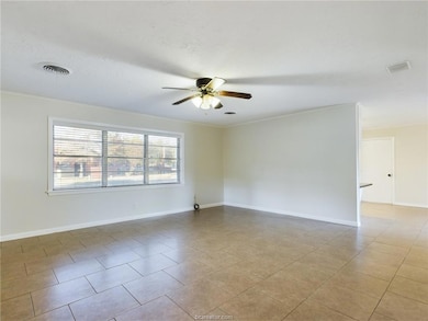 Spare room with ornamental molding, ceiling fan, and light tile patterned floors