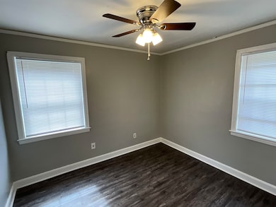 Empty room with crown molding, ceiling fan, basebo