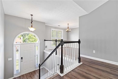 Foyer entrance featuring a textured ceiling, crown