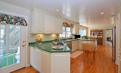 The sizable kitchen boasts plentiful white cabinet